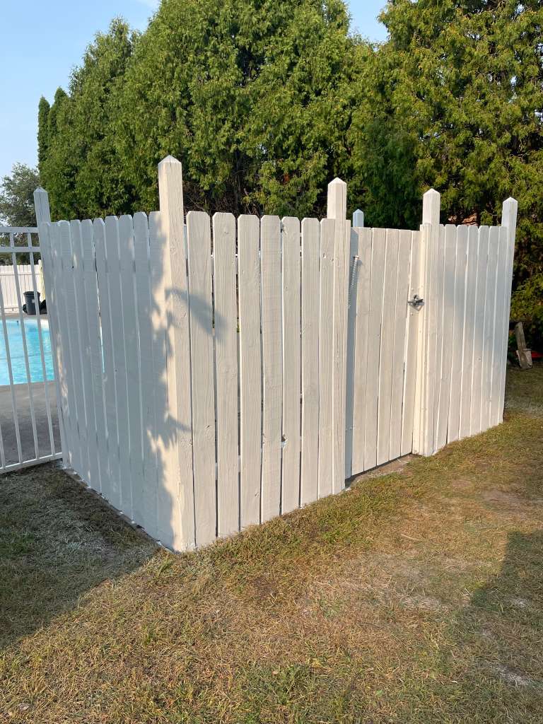 Wood fence after — bright white and renewed